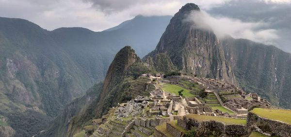 Panoramic view of mountain range against cloudy sky