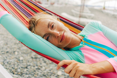 Happy smiling carefree young woman relaxing in a hammock on the beach.