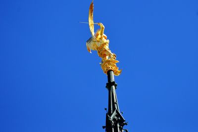 Low angle view of statue against clear blue sky