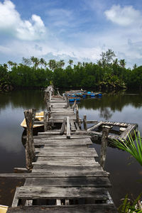 Wooden pier over lake against sky