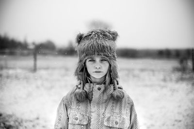 Portrait of young woman standing against lake