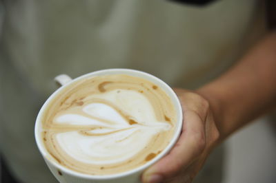 Cropped image of hand holding coffee cup