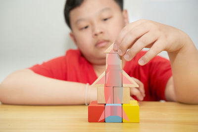 Close-up of boy holding toy against white background
