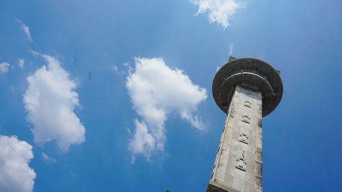 Low angle view of lighthouse by building against sky