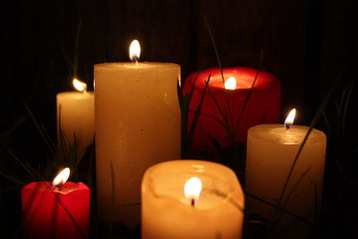 Close-up of lit tea light candles in the dark