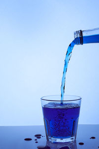 Close-up of wine glass on table against blue background