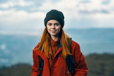 Portrait of beautiful young woman standing in park during winter