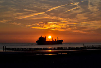 Silhouette ship on sea against sky during sunset