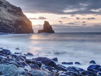 Blue sunset at rocky coast of sea. slow shutter speed for smooth water level and dreamy effect