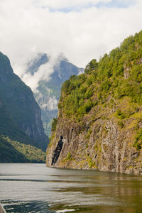 Scenic view of river and mountains against sky