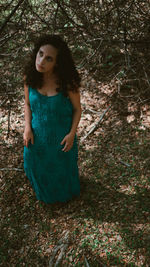 Young woman standing against plants