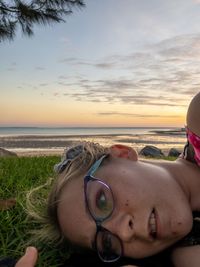 Portrait of man wearing sunglasses at beach during sunset