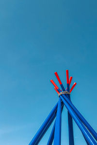 Low angle view of red umbrella against clear blue sky