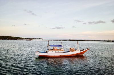 Boat sailing in sea against sky