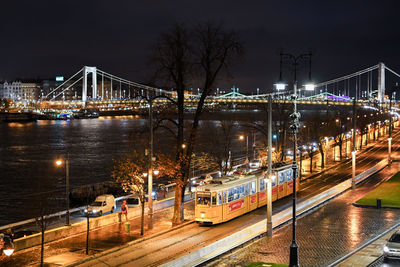 Illuminated bridge over river at night