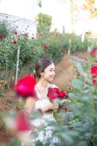 Side view of woman blowing flowers