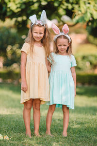 Full length of sisters standing outdoors