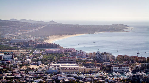 High angle view of townscape by sea against sky