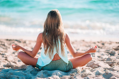 Midsection of woman sitting on beach