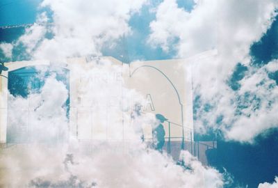 Digital composite image of glass window against cloudy sky