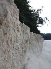 Close-up of sand on beach against sky