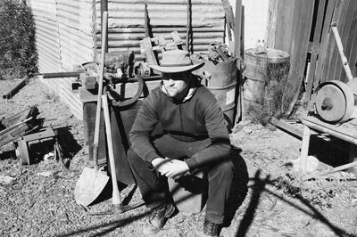 Man sitting outside workshop during sunny day