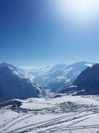 Scenic view of snowcapped mountains against blue sky