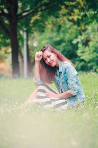 Portrait of beautiful young woman lying on field