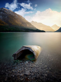 Scenic view of lake by mountains against sky