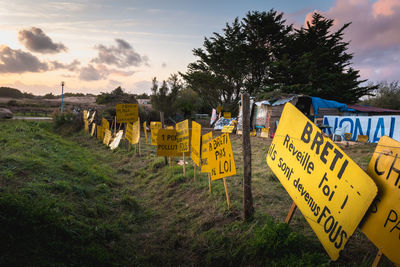 Information sign on field against sky