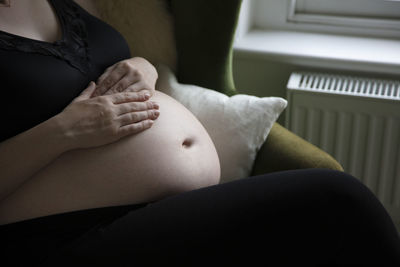 Midsection of woman touching at home