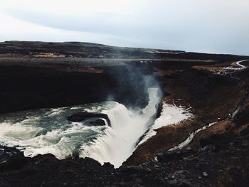 Scenic view of waterfall against sky