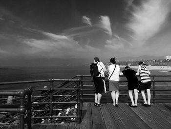 Rear view of man overlooking calm sea