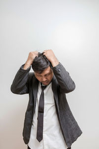 Young man standing against white background