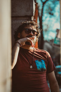 Portrait of young man standing against wall