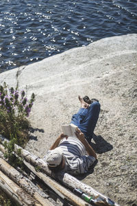 High angle view of man reading book at island on sunny day