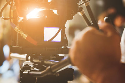 Cropped image of man using video camera on sunny day