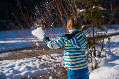 Girl standing on snow covered tree