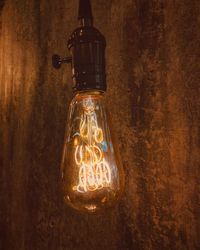 Close-up of illuminated light bulb on wall