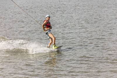 Full length of a man holding surfboard in sea