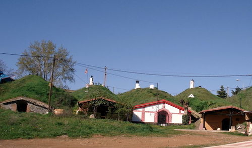 Houses and buildings against clear blue sky