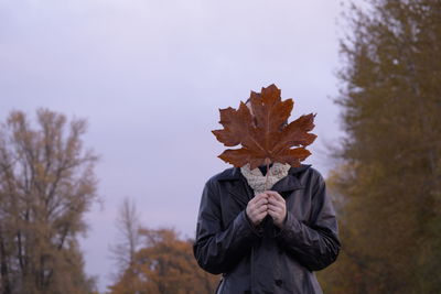 Person holding maple leaves during autumn