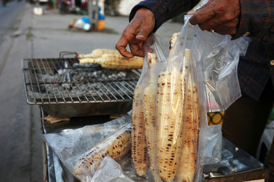 Midsection of man preparing food on barbecue grill