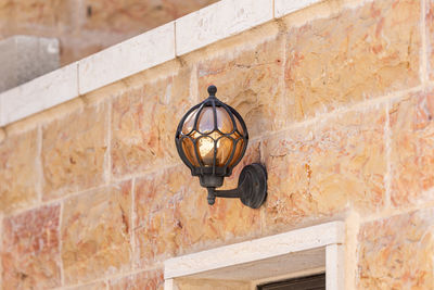 Low angle view of lantern hanging on wall