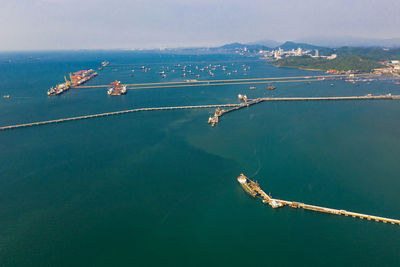 Seascape and oil station bridge with sailing shipping oil and gas on the green sea aerial view 