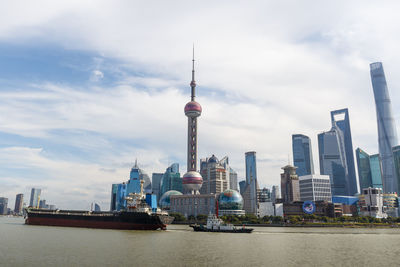 Modern buildings in city against cloudy sky