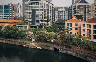 Arch bridge over river by buildings in city