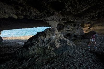 Woman standing on rock by sea