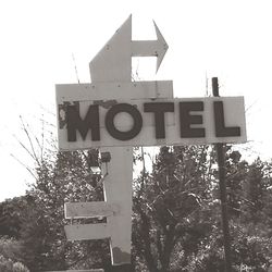 Low angle view of road sign against clear sky