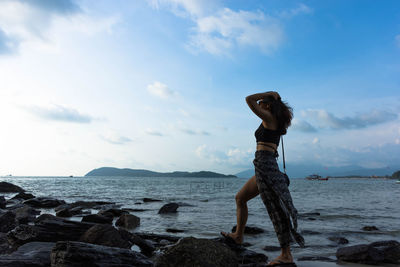 Full length of woman on beach against sky